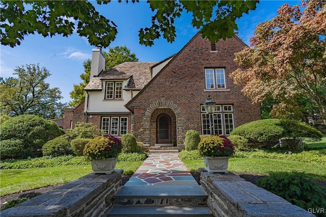 english style home featuring a front lawn