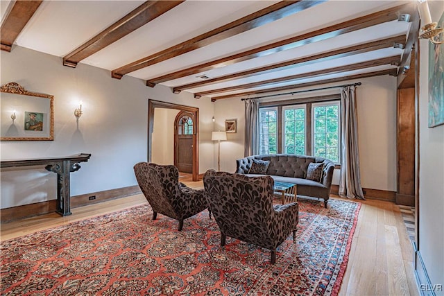 living room featuring beam ceiling and light hardwood / wood-style floors