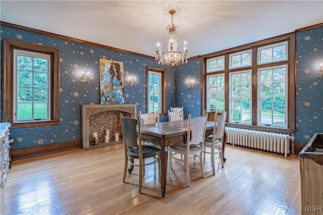 dining space featuring an inviting chandelier, crown molding, radiator heating unit, and light hardwood / wood-style floors