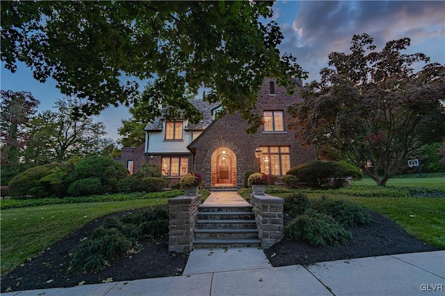 tudor home featuring a lawn