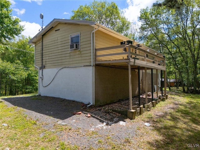 view of side of property featuring cooling unit and a deck