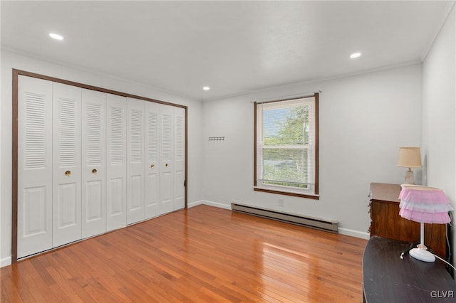 unfurnished bedroom with a baseboard radiator, light hardwood / wood-style flooring, and a closet