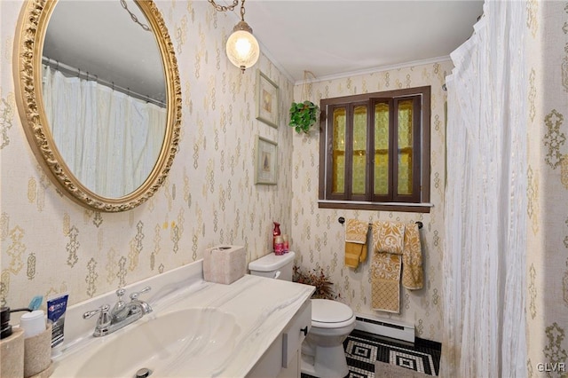 bathroom featuring a baseboard heating unit, crown molding, vanity, and toilet