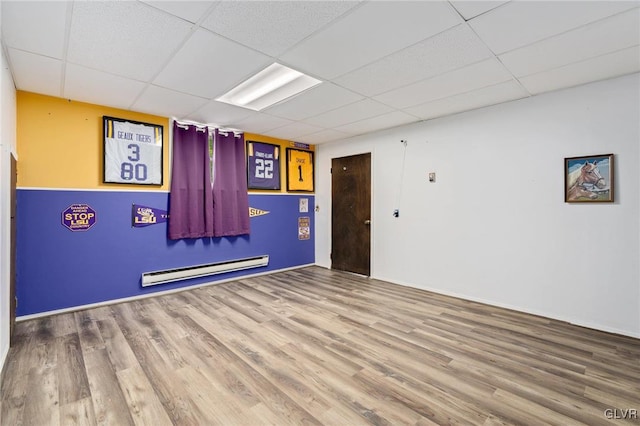 empty room featuring a drop ceiling and hardwood / wood-style flooring