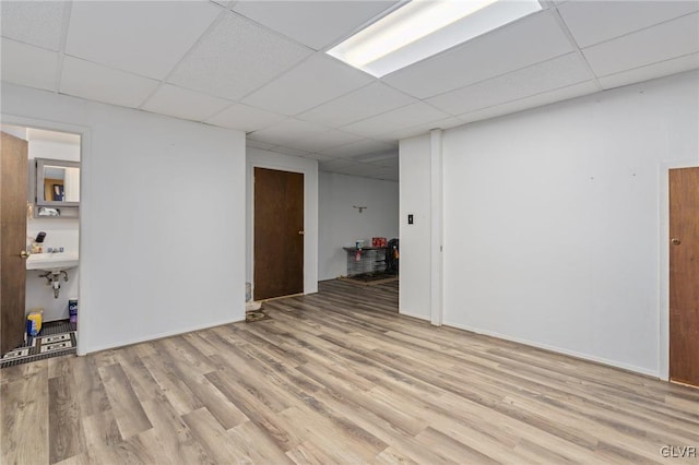 spare room featuring light wood-type flooring, a paneled ceiling, and sink