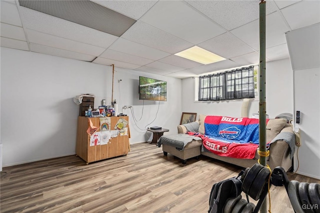 living room featuring wood-type flooring and a paneled ceiling