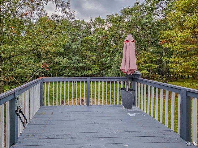 wooden deck featuring a lawn