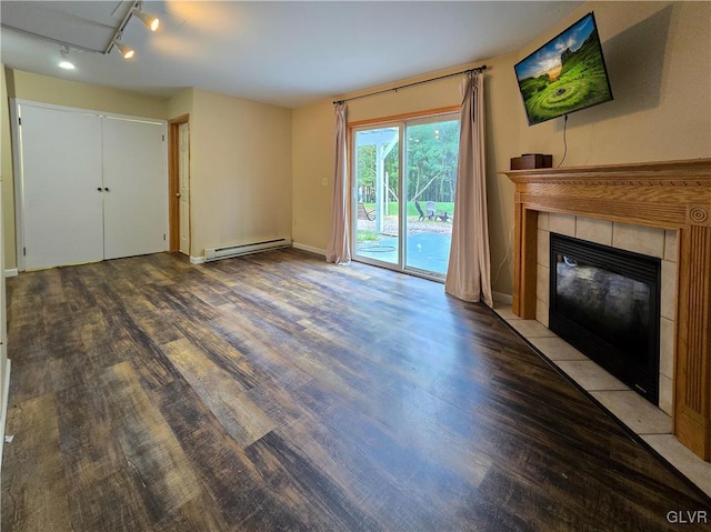 unfurnished living room with a baseboard radiator, a tiled fireplace, hardwood / wood-style flooring, and rail lighting