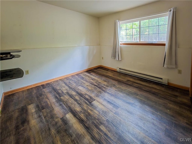 unfurnished room with a baseboard heating unit and dark hardwood / wood-style floors