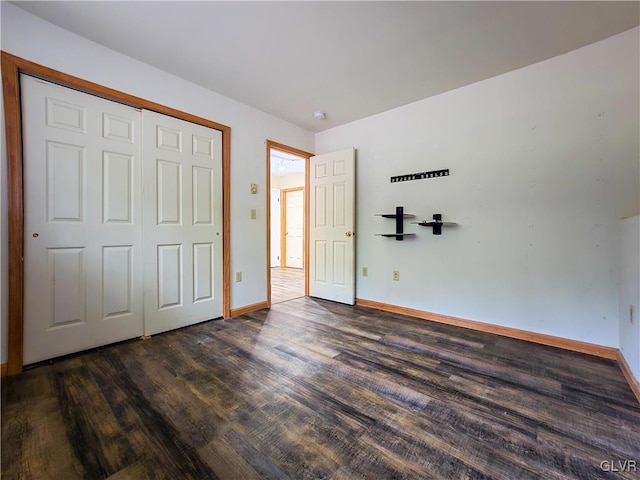 unfurnished bedroom with dark hardwood / wood-style flooring and a closet