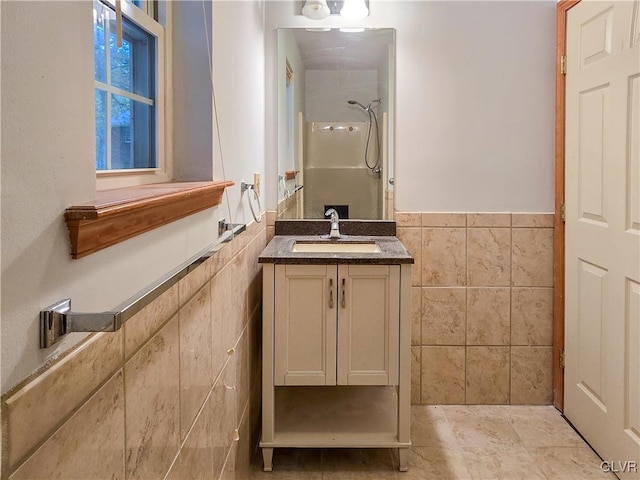 bathroom with tile walls, walk in shower, and vanity