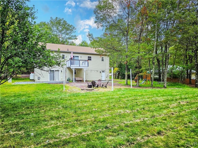 back of property featuring a fire pit, a patio area, a playground, and a yard