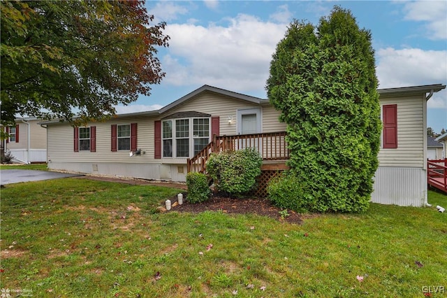 manufactured / mobile home featuring a wooden deck and a front yard