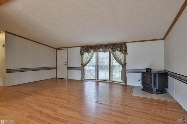 unfurnished living room featuring a textured ceiling, light hardwood / wood-style floors, and a wood stove