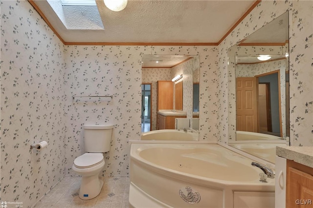 bathroom featuring a skylight, toilet, a washtub, a textured ceiling, and tile patterned flooring