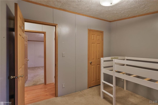 bedroom with a textured ceiling, light carpet, and a closet