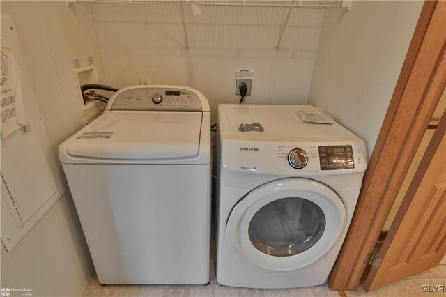 laundry room with light tile patterned floors and washing machine and dryer