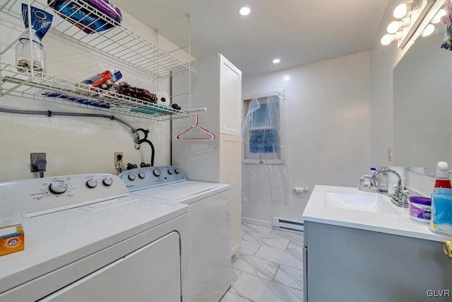 laundry area with a baseboard radiator, sink, and washing machine and dryer