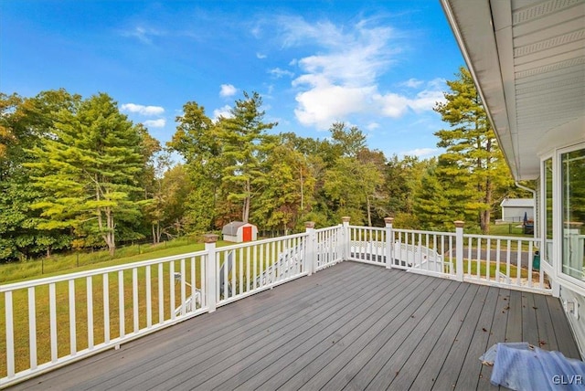 deck featuring a storage shed and a yard