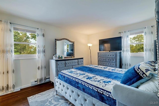 bedroom with a baseboard heating unit and dark hardwood / wood-style flooring