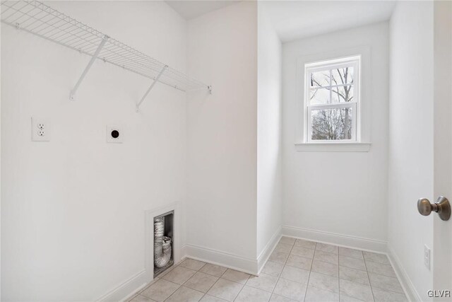 laundry area with hookup for an electric dryer and light tile patterned floors