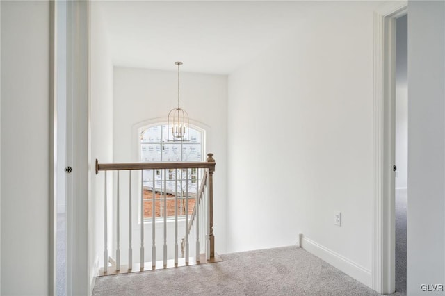 hall featuring a chandelier and carpet floors