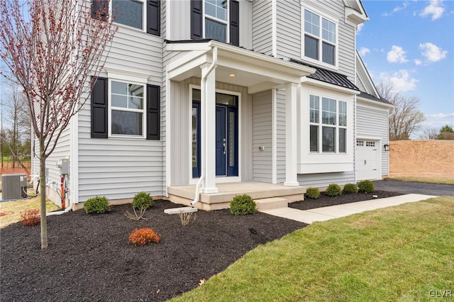 view of front of house with central air condition unit, a front yard, and a garage