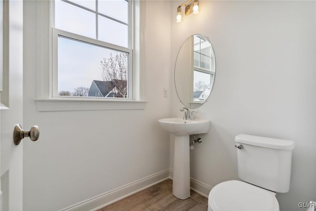 bathroom featuring toilet, wood-type flooring, and plenty of natural light