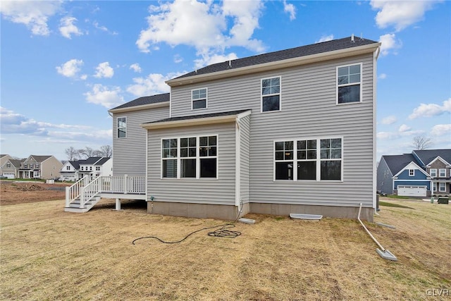 back of property featuring a wooden deck and a yard