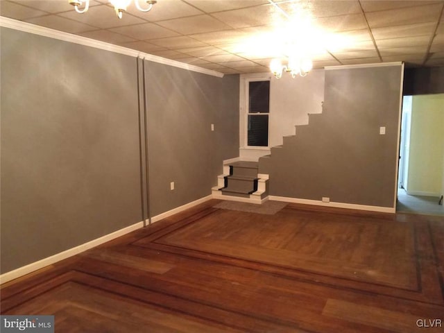 basement with crown molding, a paneled ceiling, a chandelier, and hardwood / wood-style flooring