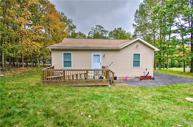 rear view of house featuring a wooden deck, a patio area, and a yard