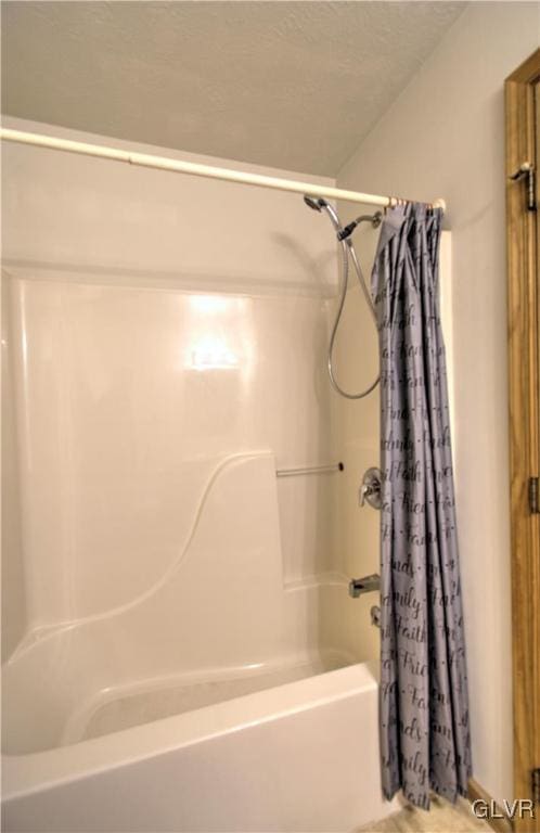 bathroom with shower / bath combination with curtain and a textured ceiling