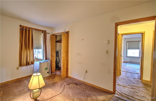 carpeted spare room with a baseboard radiator