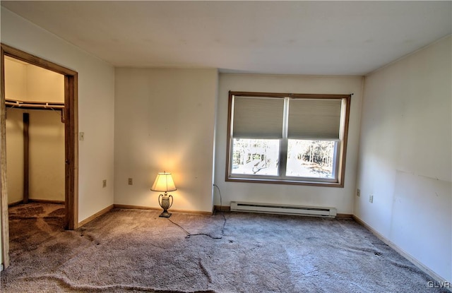 unfurnished bedroom featuring baseboard heating, carpet floors, and a spacious closet