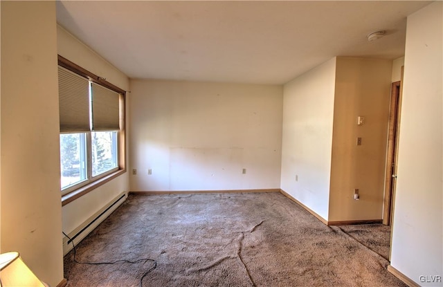 spare room featuring carpet flooring and a baseboard heating unit