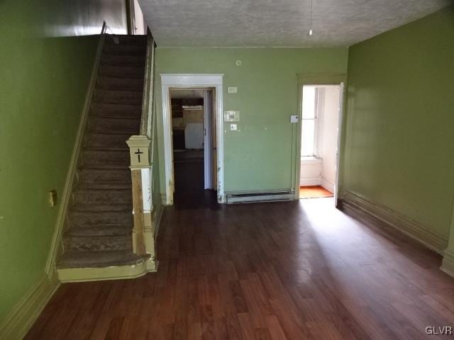 unfurnished living room featuring hardwood / wood-style flooring and a textured ceiling