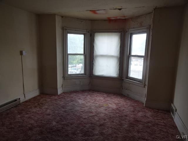 unfurnished room with a wealth of natural light and carpet