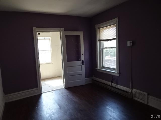 unfurnished room with dark hardwood / wood-style flooring