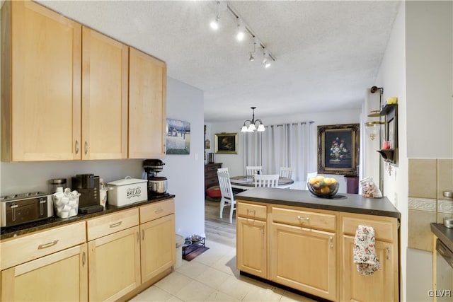 kitchen featuring dishwasher, pendant lighting, light brown cabinets, a textured ceiling, and a chandelier