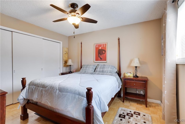 bedroom featuring a closet, ceiling fan, light parquet flooring, and a textured ceiling