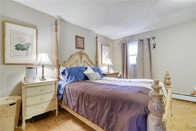 bedroom featuring a baseboard heating unit, a textured ceiling, and light parquet flooring