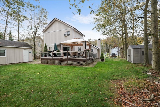 rear view of house featuring a gazebo, a deck, a yard, and a shed