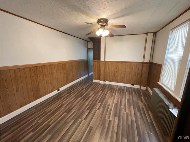 spare room featuring crown molding, radiator heating unit, dark hardwood / wood-style floors, and ceiling fan