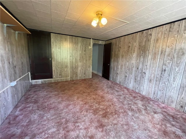 unfurnished bedroom featuring carpet floors and wooden walls