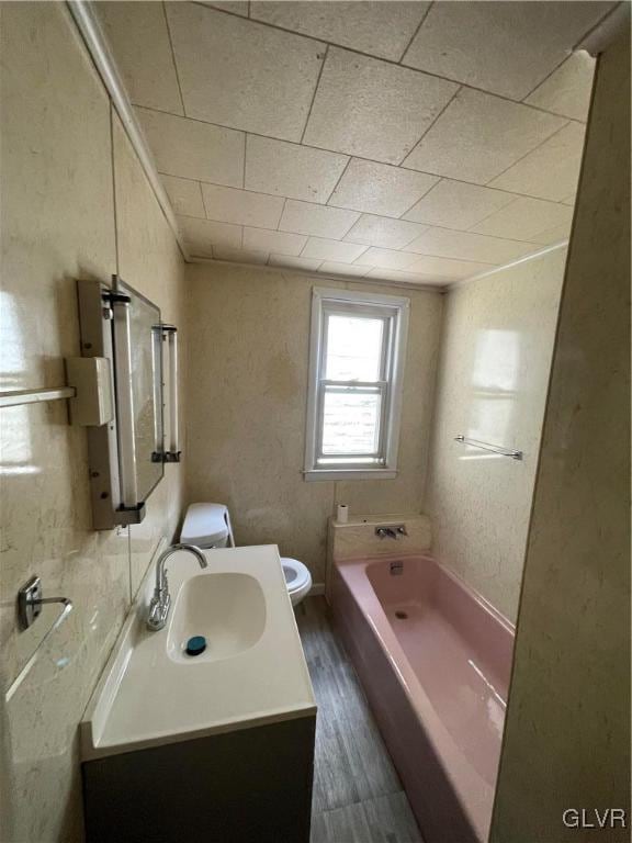 full bathroom with shower / bathtub combination, wood-type flooring, vanity, and toilet