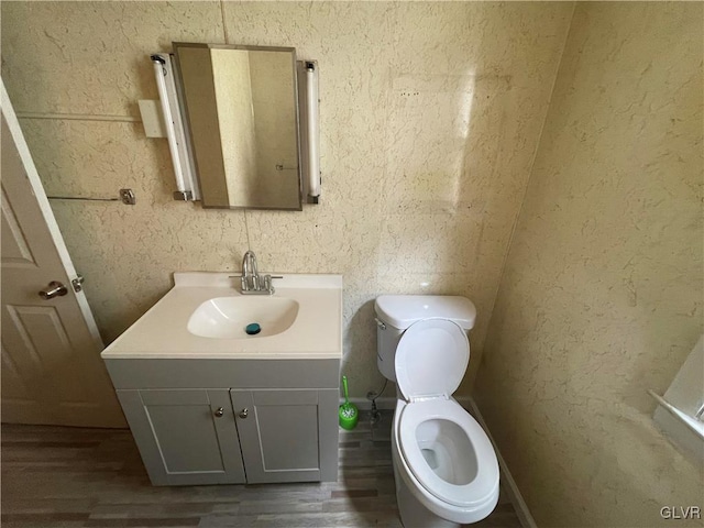 bathroom featuring vanity, toilet, and hardwood / wood-style flooring