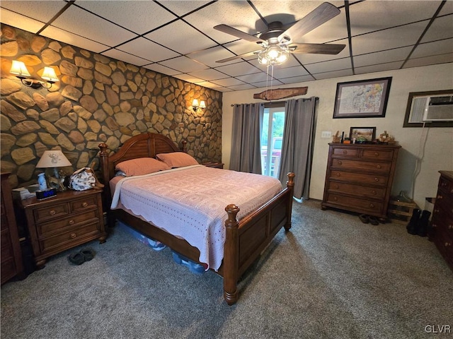 bedroom featuring a paneled ceiling, a wall mounted AC, dark colored carpet, and ceiling fan