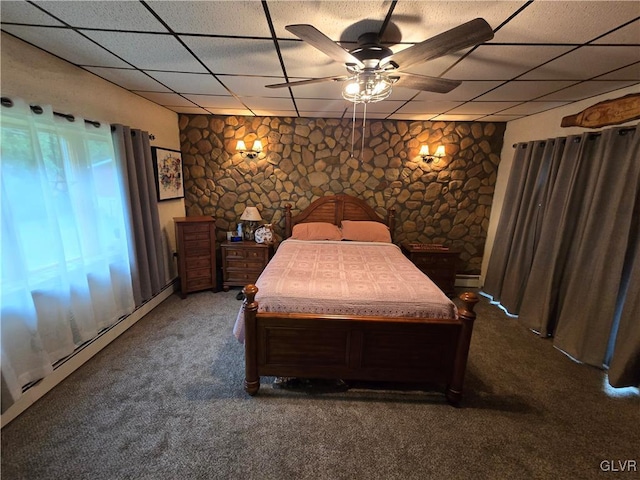 bedroom featuring a paneled ceiling, dark colored carpet, and ceiling fan