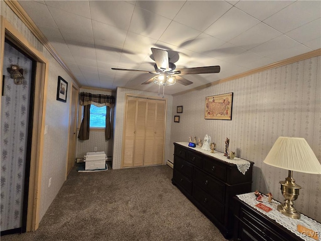 bedroom with ceiling fan, a baseboard heating unit, carpet, a closet, and crown molding