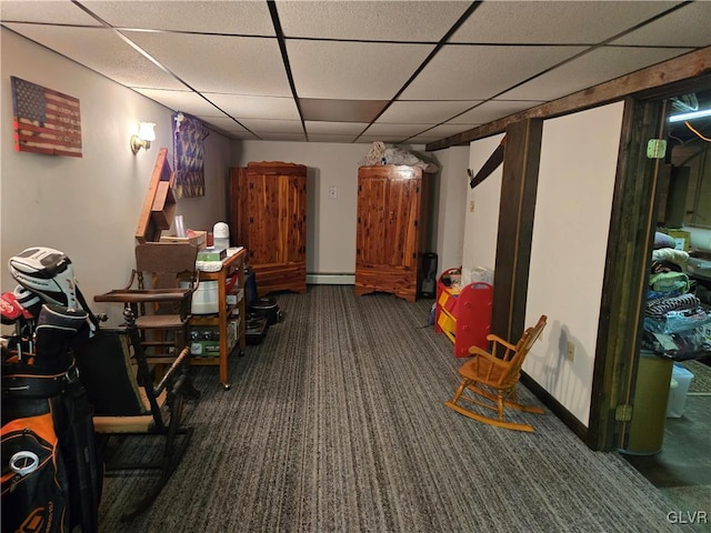 interior space with dark carpet, a baseboard radiator, and a drop ceiling